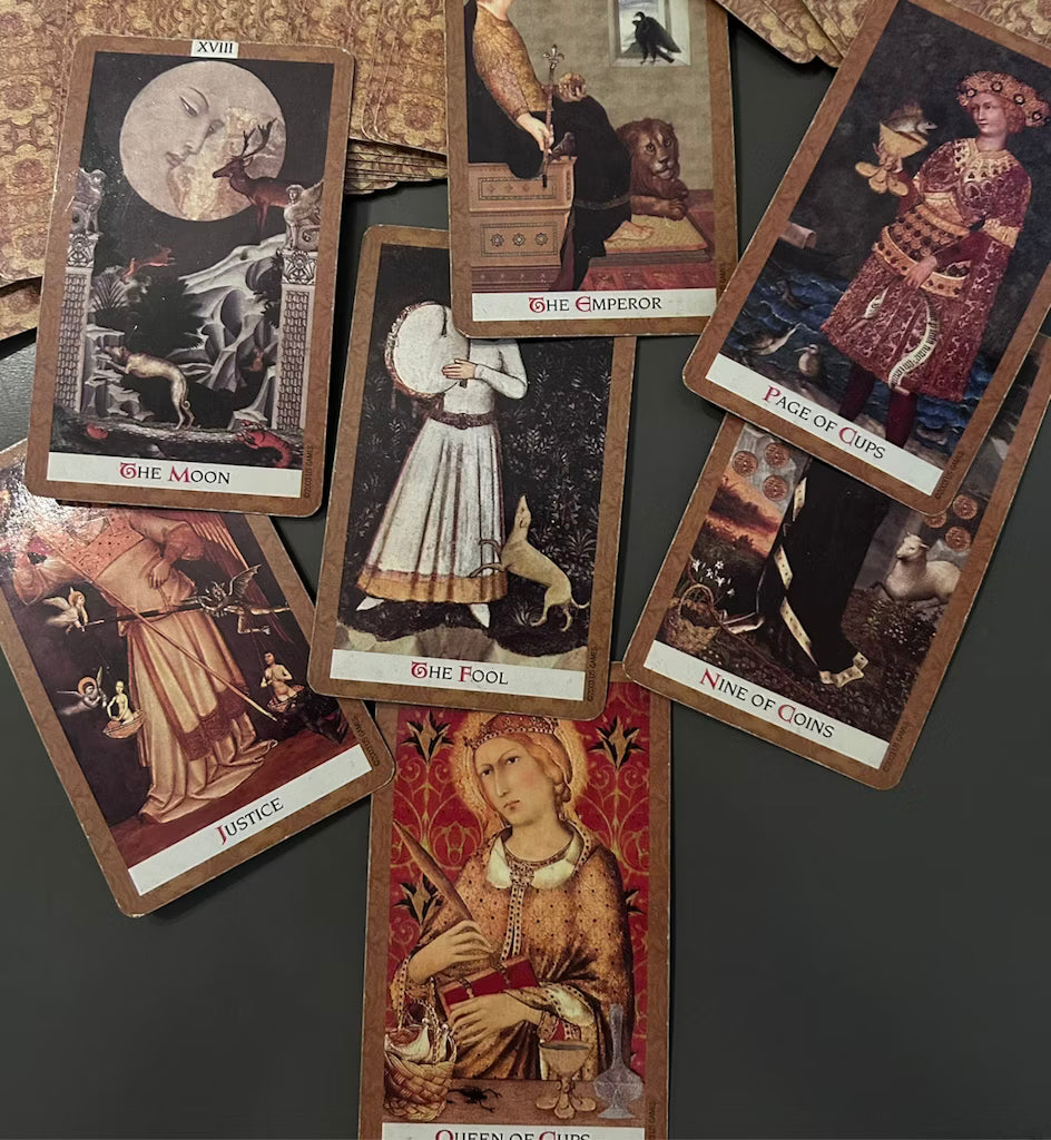 A spread of tarot and chakra-related cards on a table, symbolizing energetic insights and divination.