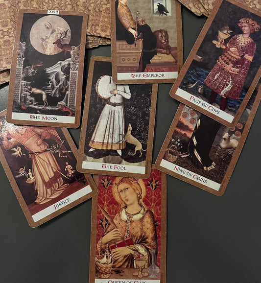 A spread of tarot and chakra-related cards on a table, symbolizing energetic insights and divination.