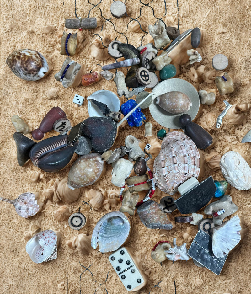 Collection of divination bones and shells arranged on a textured surface, representing spiritual guidance practices.
