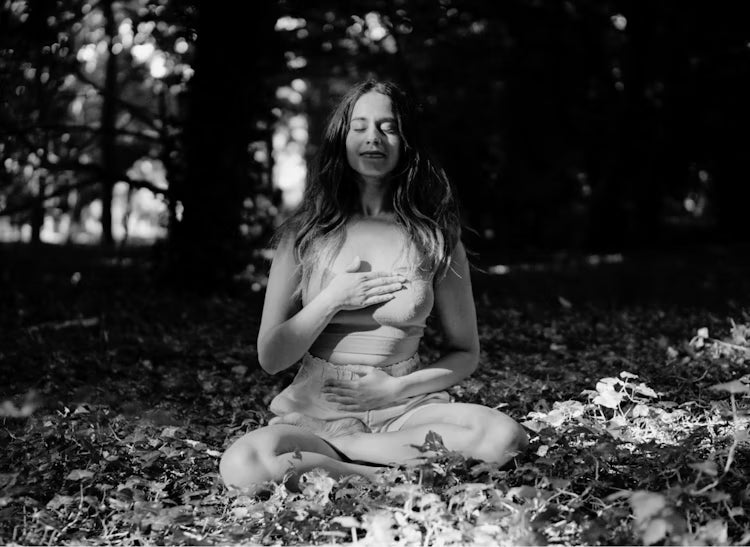 A person dancing gracefully in a soft, neutral-toned room, expressing fluid motion and freedom through movement.