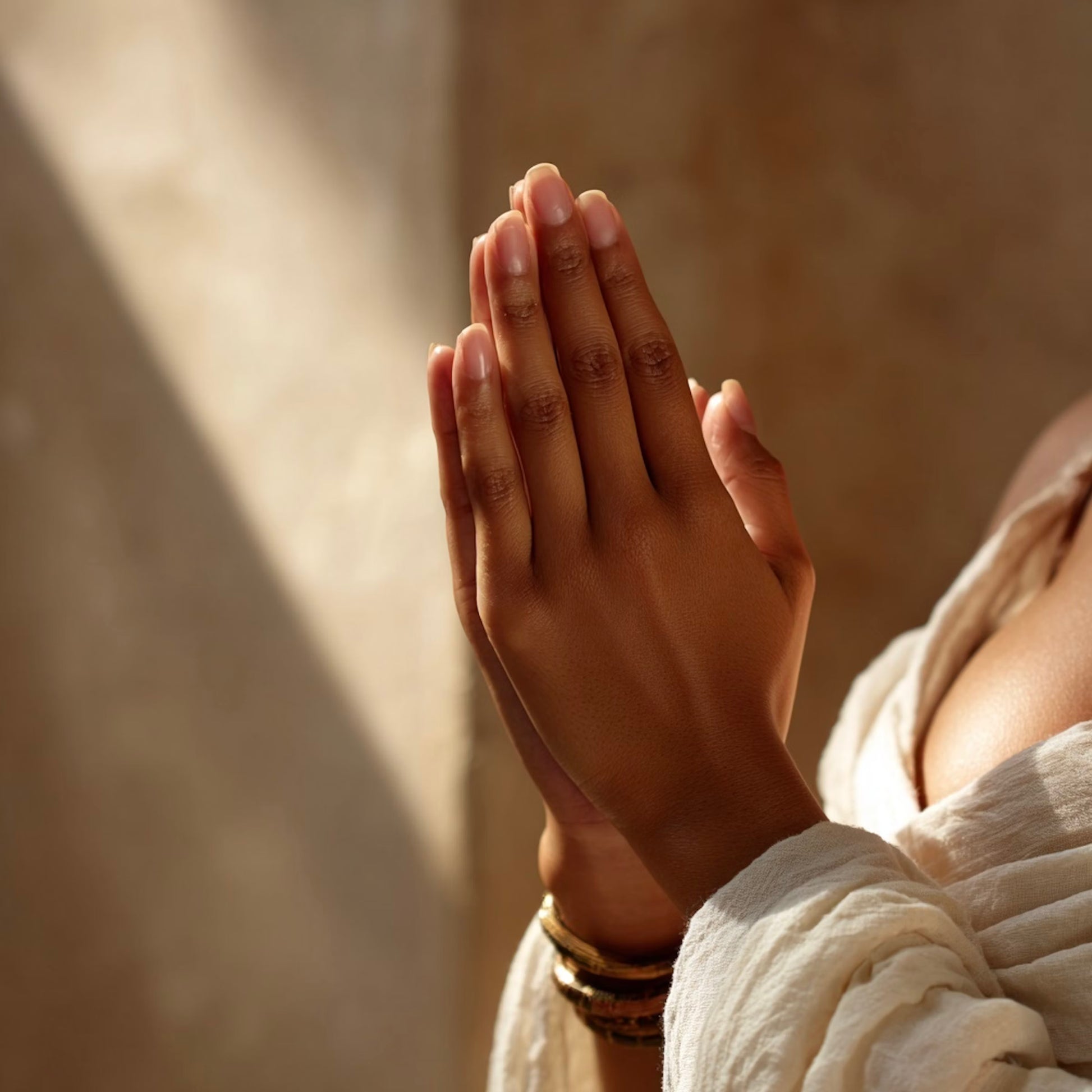 Hands gently clasped in prayer-like gesture with warm light, symbolizing love and spiritual ties.